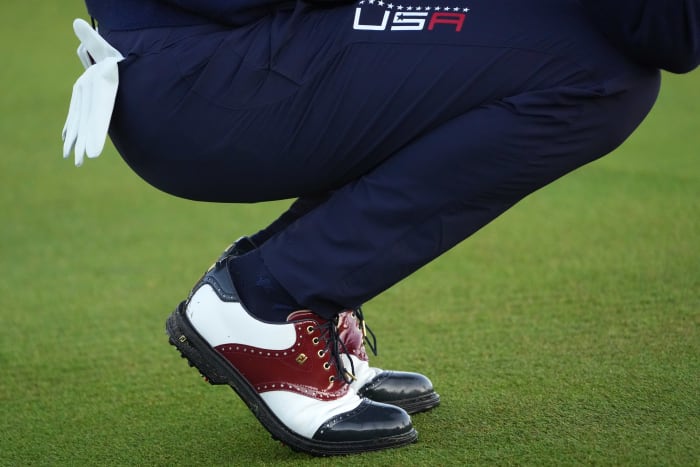 Side view of Justin Thomas' white and navy FootJoy golf shoes.